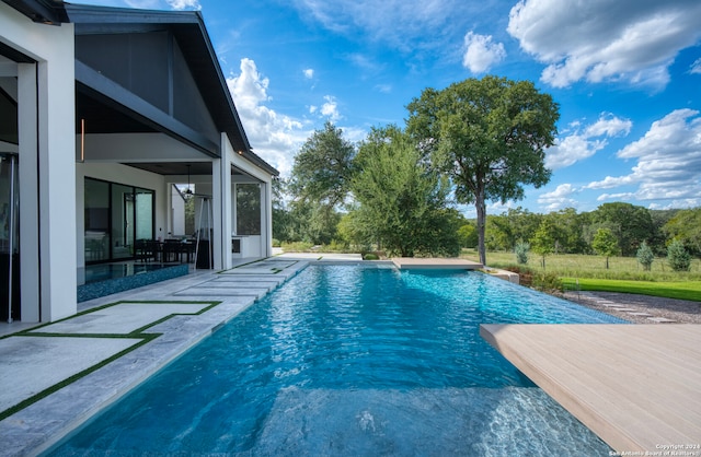 view of pool with a patio and pool water feature