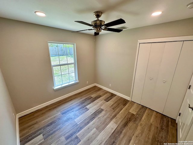 unfurnished bedroom featuring light wood-type flooring, ceiling fan, and a closet