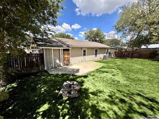 rear view of house with central air condition unit, a yard, and a patio