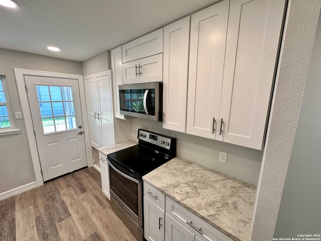 kitchen featuring light wood-type flooring, appliances with stainless steel finishes, and white cabinets