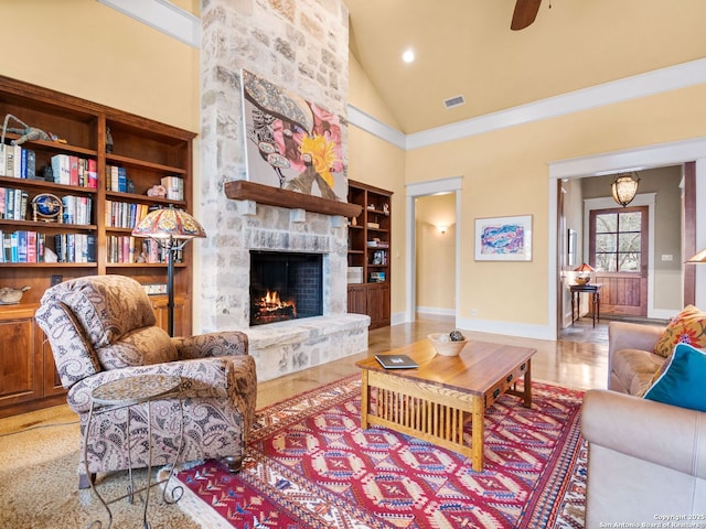 living area with built in shelves, a fireplace, visible vents, high vaulted ceiling, and baseboards