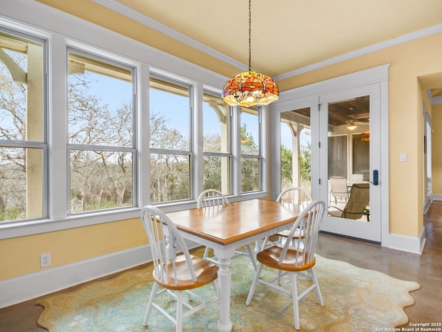 dining room with baseboards, plenty of natural light, and crown molding