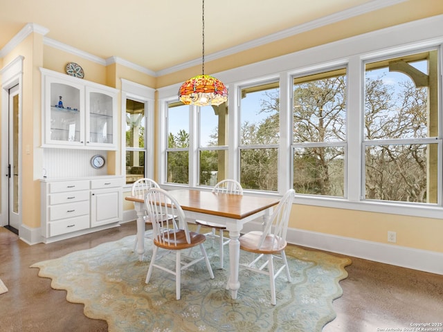 dining space with crown molding and baseboards