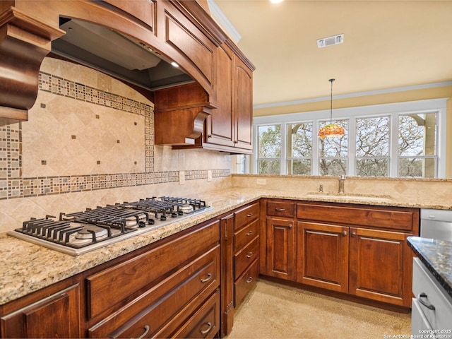 kitchen with tasteful backsplash, visible vents, stainless steel appliances, premium range hood, and a sink