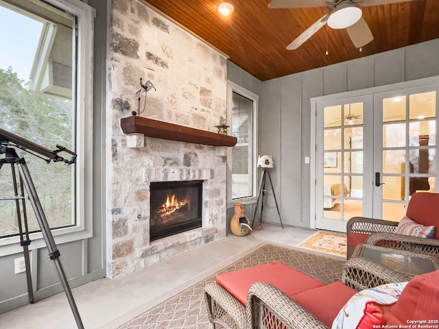 living room with ceiling fan, french doors, wooden ceiling, and a fireplace