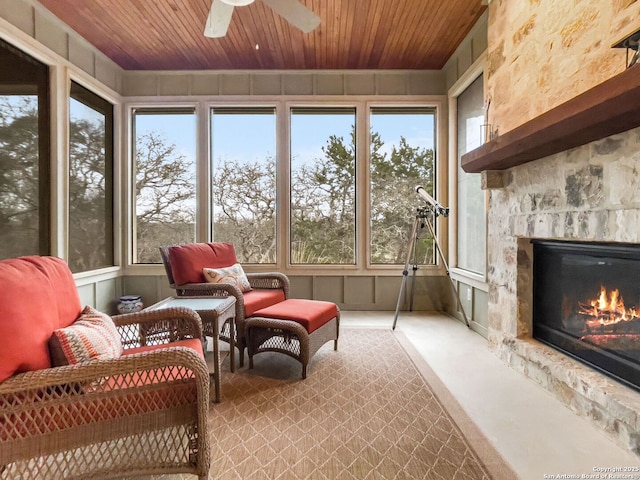 sunroom with a healthy amount of sunlight, wood ceiling, and a stone fireplace