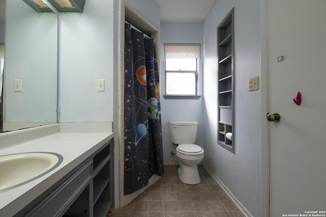 bathroom with toilet, baseboards, and vanity