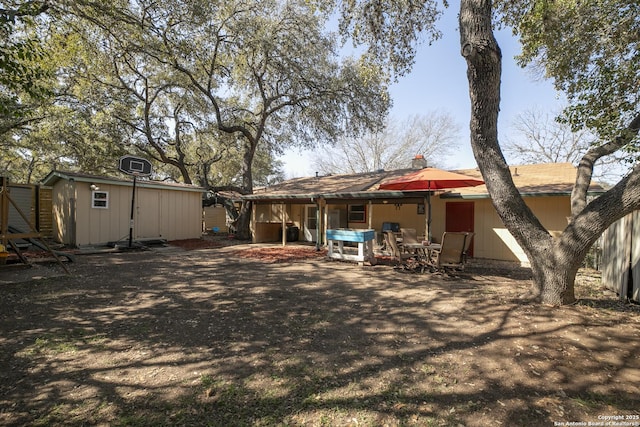 rear view of house featuring an outbuilding, a patio area, and a shed