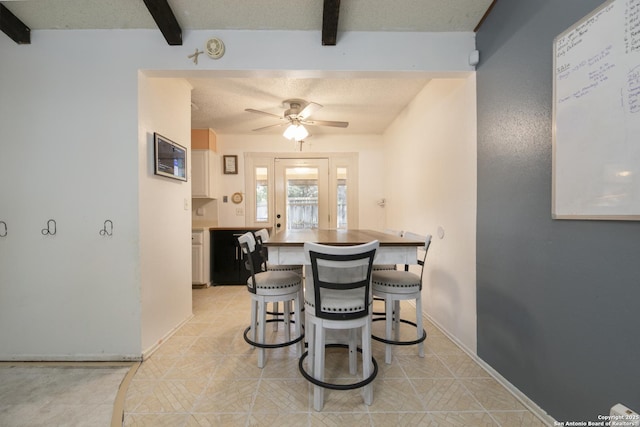 dining area with a ceiling fan, beam ceiling, a textured ceiling, and baseboards