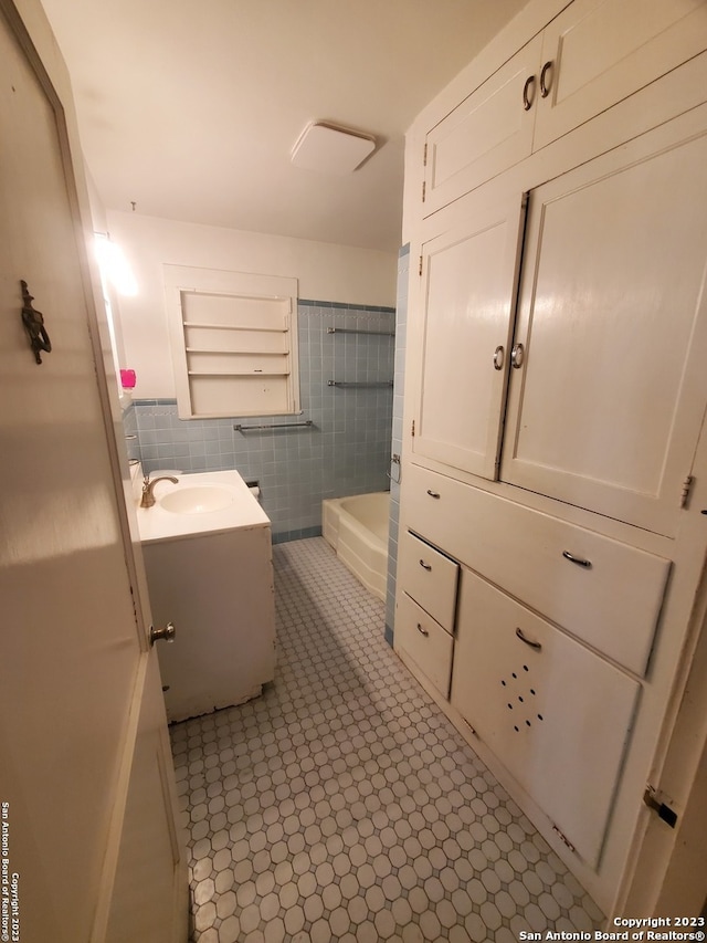 bathroom featuring vanity, tile walls, and a washtub