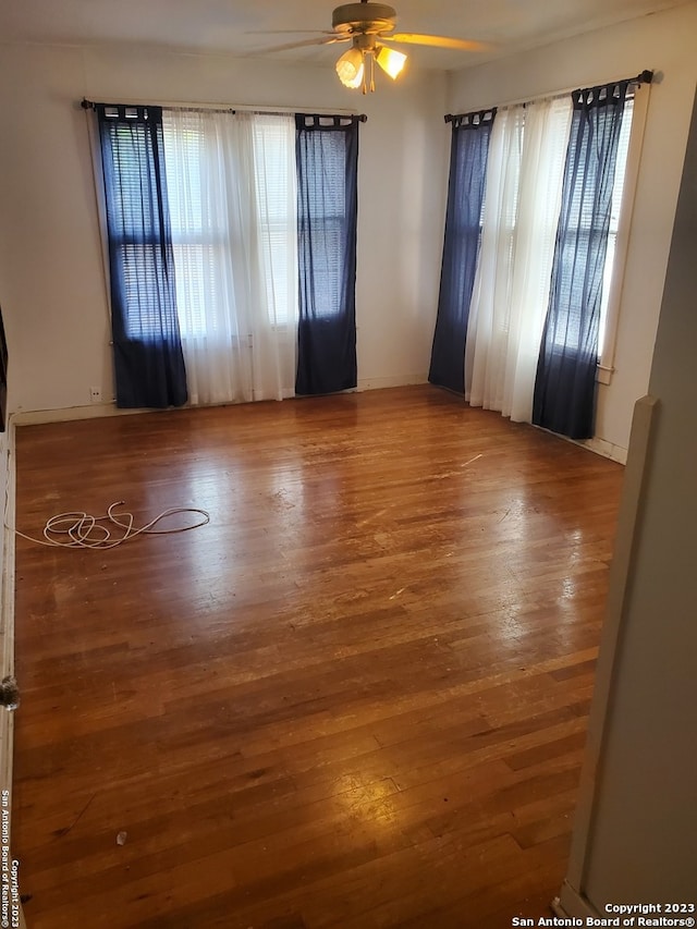 unfurnished room with ceiling fan and wood-type flooring