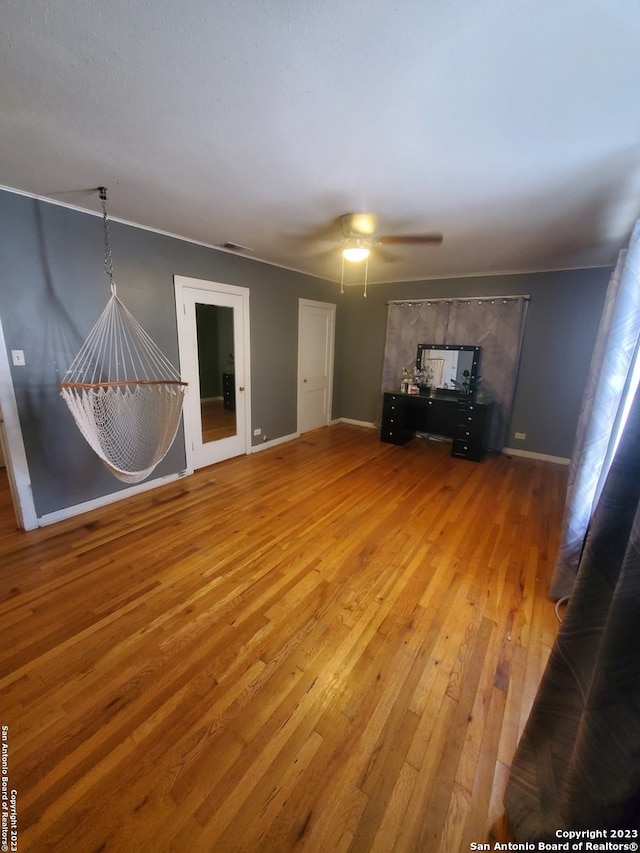 unfurnished living room with ceiling fan and hardwood / wood-style floors