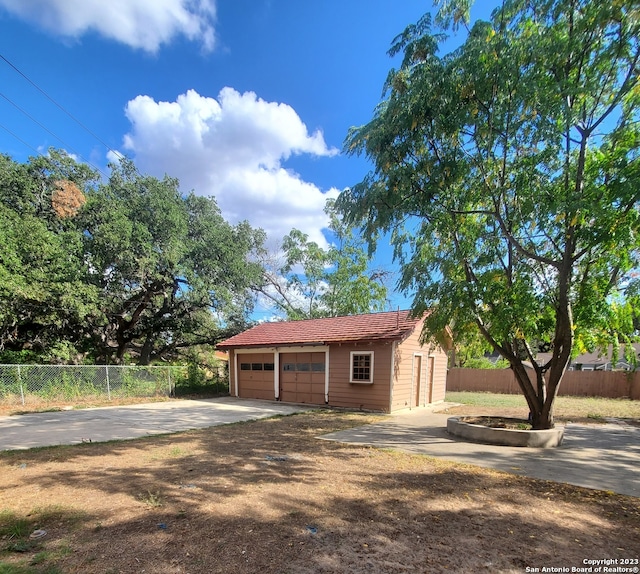 view of front of house featuring a garage and an outbuilding