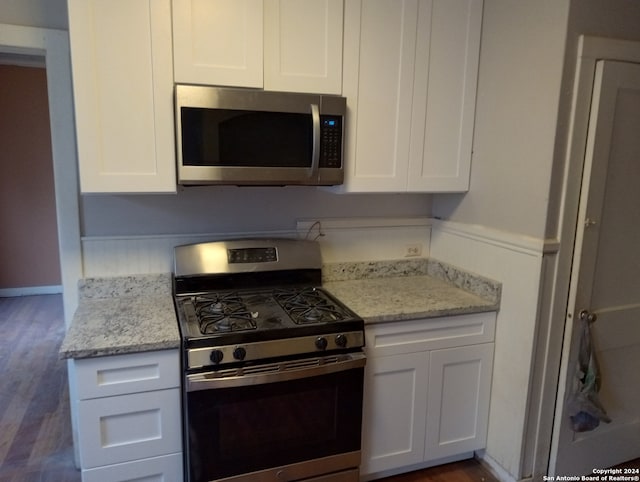 kitchen featuring dark wood-type flooring, stainless steel appliances, and white cabinets