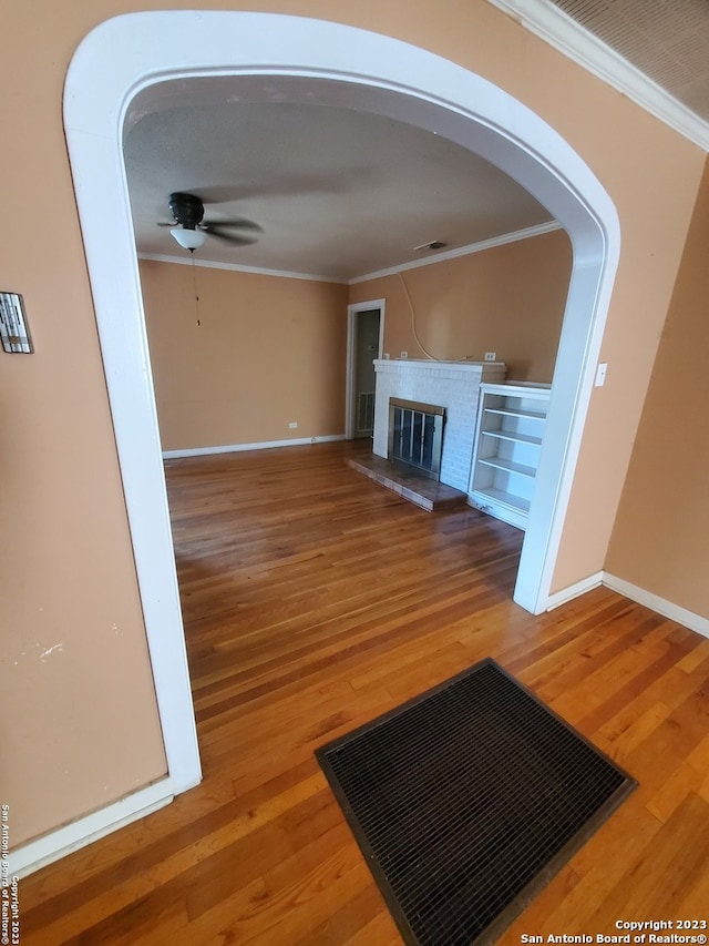 unfurnished living room featuring crown molding, ceiling fan, and wood-type flooring