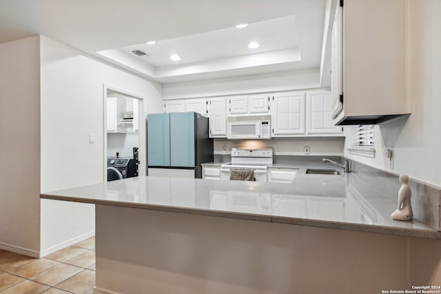 kitchen featuring kitchen peninsula, sink, white appliances, and white cabinets