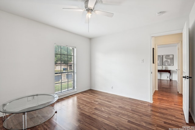 unfurnished room with ceiling fan and dark hardwood / wood-style flooring