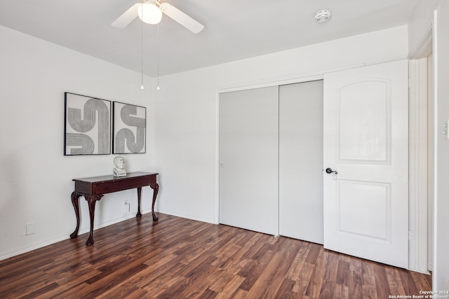 bedroom featuring dark wood-type flooring, ceiling fan, and a closet