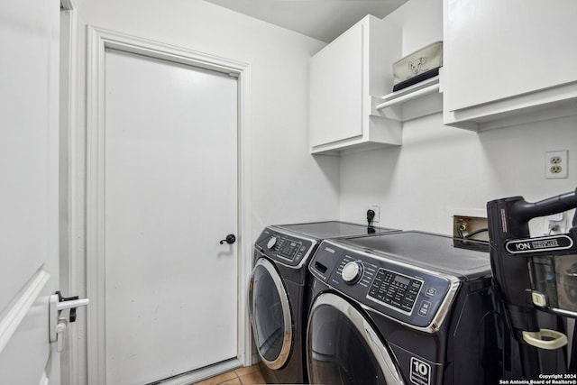 washroom featuring cabinets and washer and clothes dryer