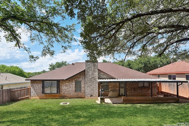 rear view of property featuring a lawn