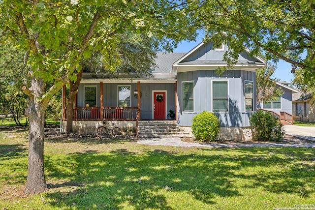 view of front of house with a porch and a front yard