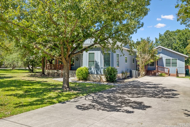 view of front of house featuring a front yard and central air condition unit