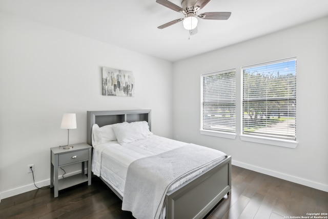 bedroom with dark hardwood / wood-style flooring and ceiling fan