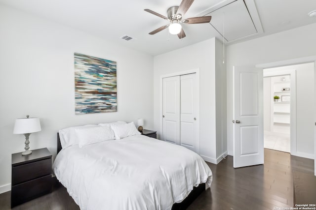 bedroom with dark wood-type flooring, ceiling fan, and a closet