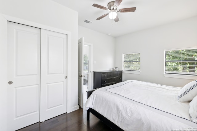 bedroom with a closet, dark hardwood / wood-style floors, and ceiling fan