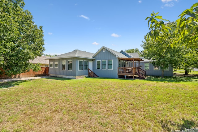 rear view of house with a deck and a lawn