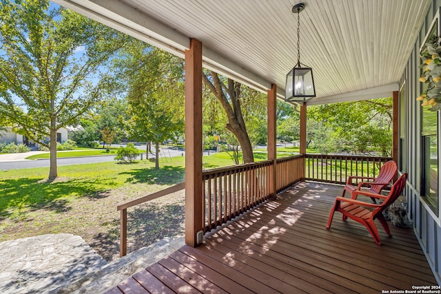 wooden terrace featuring a porch and a yard