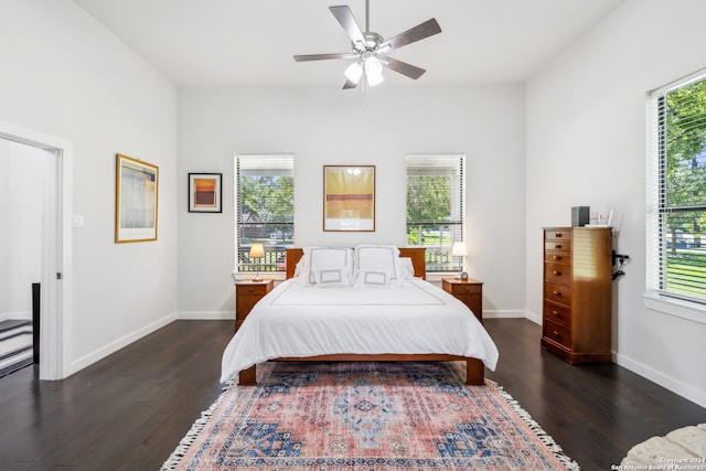 bedroom with multiple windows, dark wood-type flooring, and ceiling fan