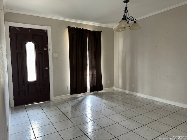 tiled foyer featuring crown molding and a notable chandelier