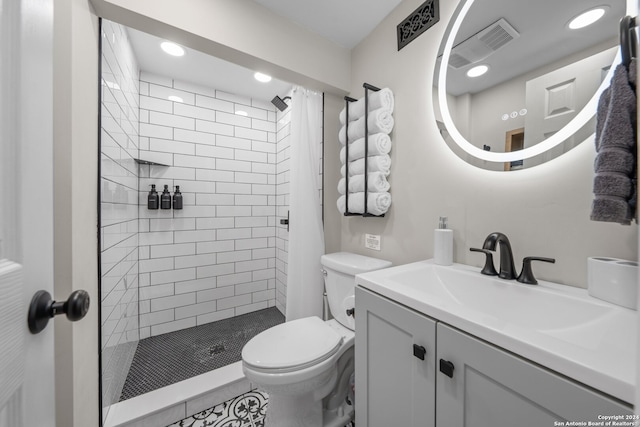 bathroom with tile patterned floors, tiled shower, toilet, and vanity