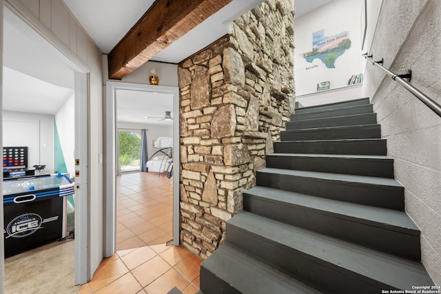 stairs featuring ceiling fan and tile patterned flooring