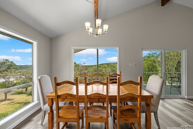 dining area featuring plenty of natural light, vaulted ceiling with beams, and light hardwood / wood-style flooring