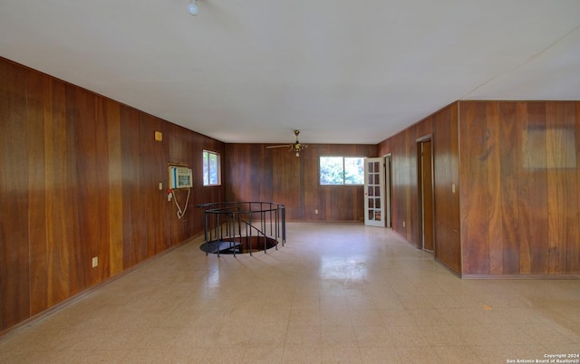 unfurnished room with light floors, wood walls, and a wall mounted AC
