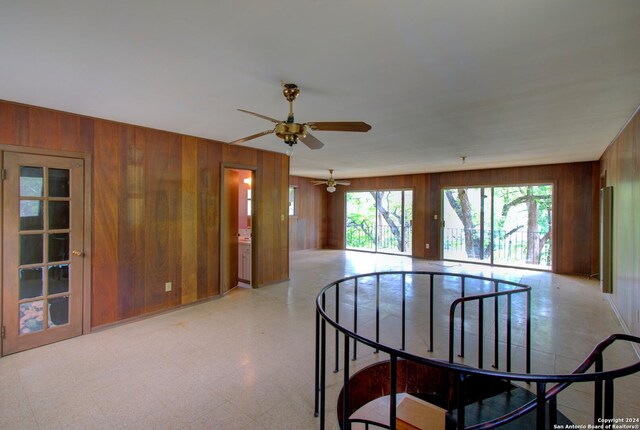 spare room with wood walls and ceiling fan