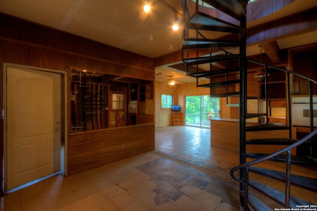 interior space with tile patterned floors and wood walls