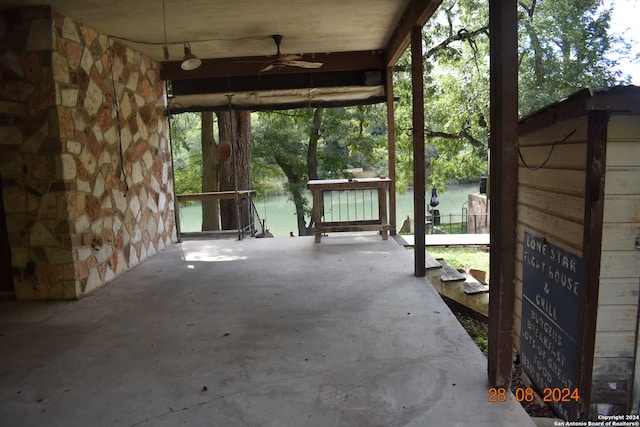 view of patio with a water view and ceiling fan