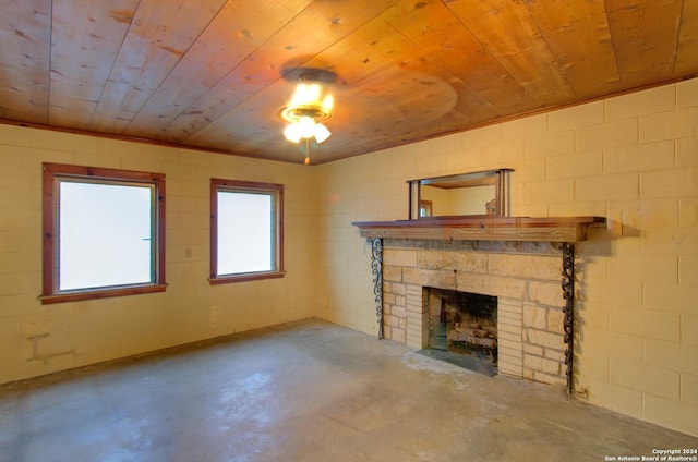 unfurnished living room featuring a stone fireplace, concrete floors, and wooden ceiling