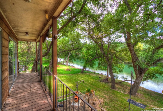 wooden terrace with a lawn and a water view