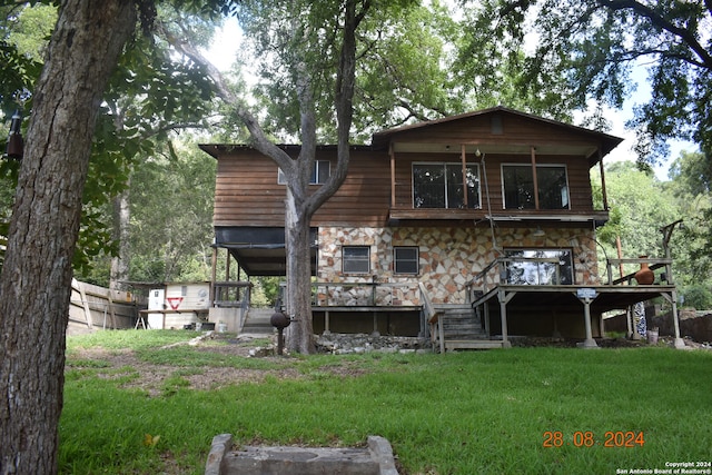 rear view of house with a yard and a wooden deck