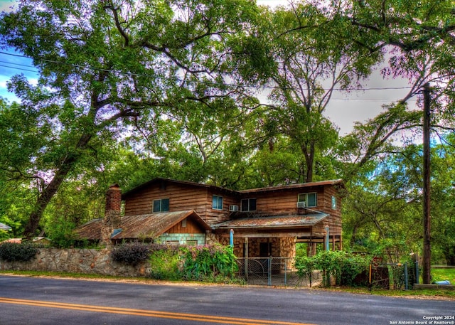 view of front facade with fence and stone siding