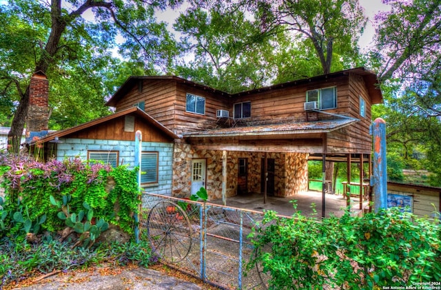 view of front of property featuring stone siding and a patio area