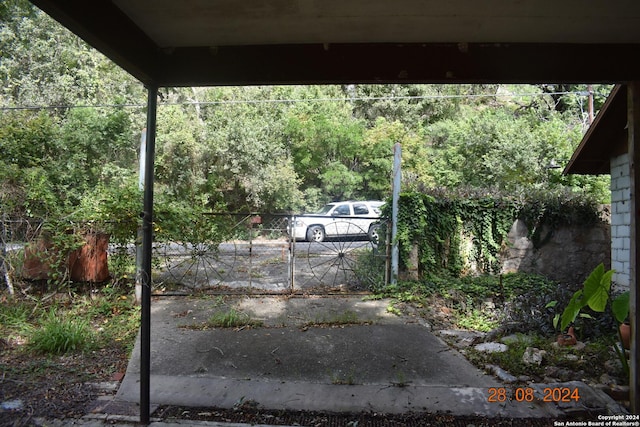 exterior space with fence, a wooded view, and a gate