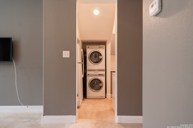 laundry room with light tile patterned floors and stacked washer and dryer