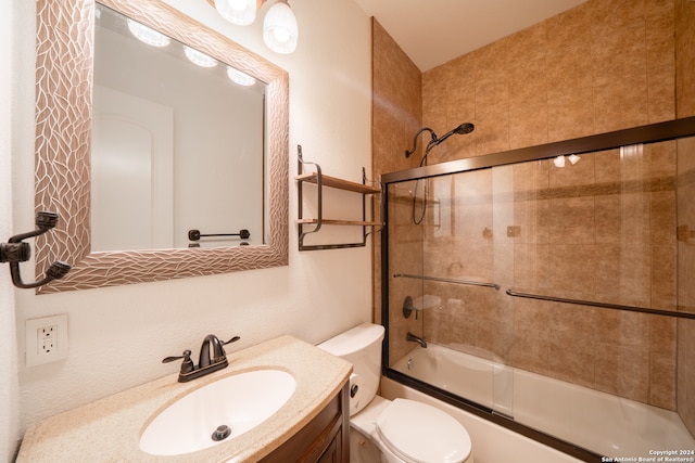 full bathroom featuring shower / bath combination with glass door, vanity, and toilet