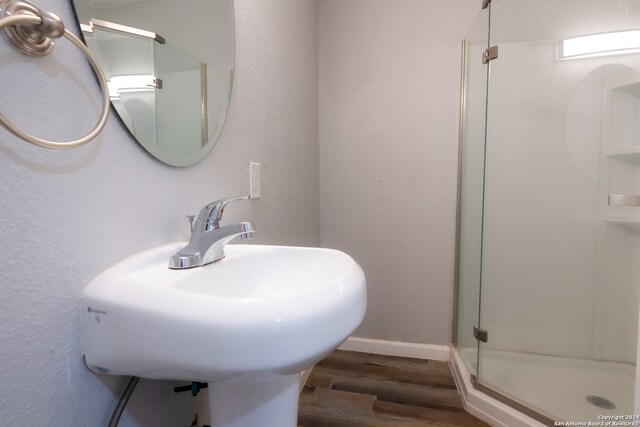 bathroom featuring an enclosed shower, hardwood / wood-style flooring, and sink