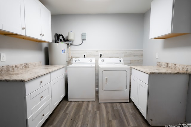 clothes washing area featuring washing machine and clothes dryer, cabinets, and dark hardwood / wood-style floors